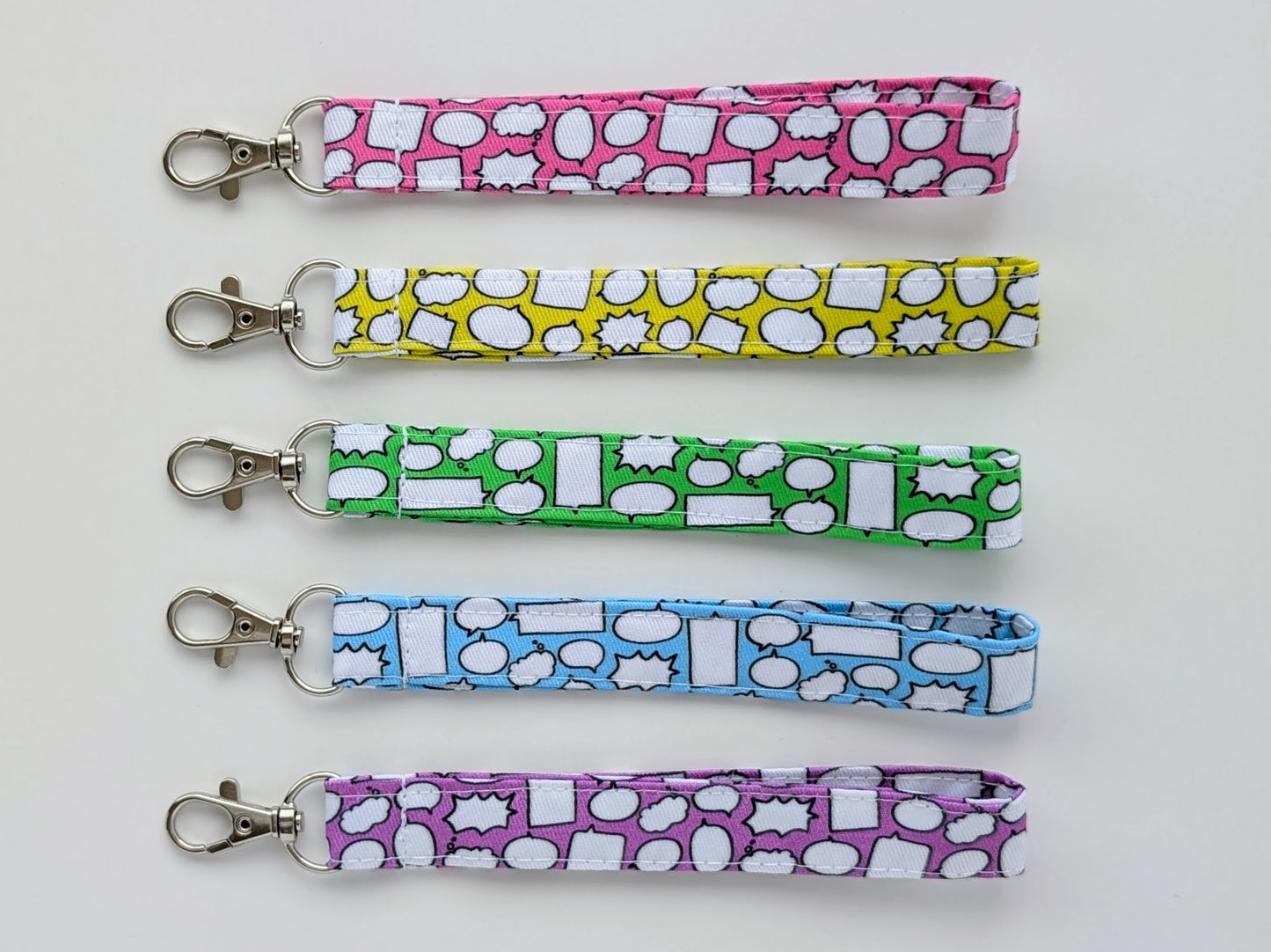 Five colorful keychains with different patterns on a white background