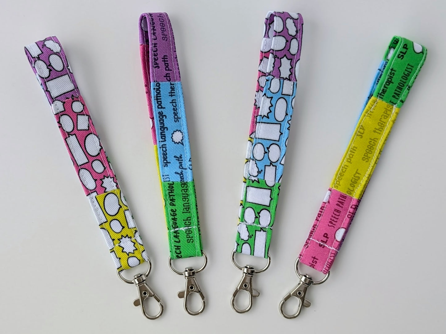 Four colorful lanyards with keychains on a light gray background
