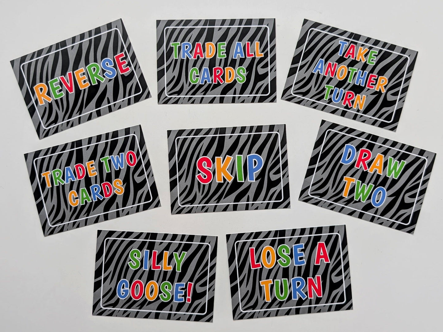 Set of game cards with colorful text on a zebra print background