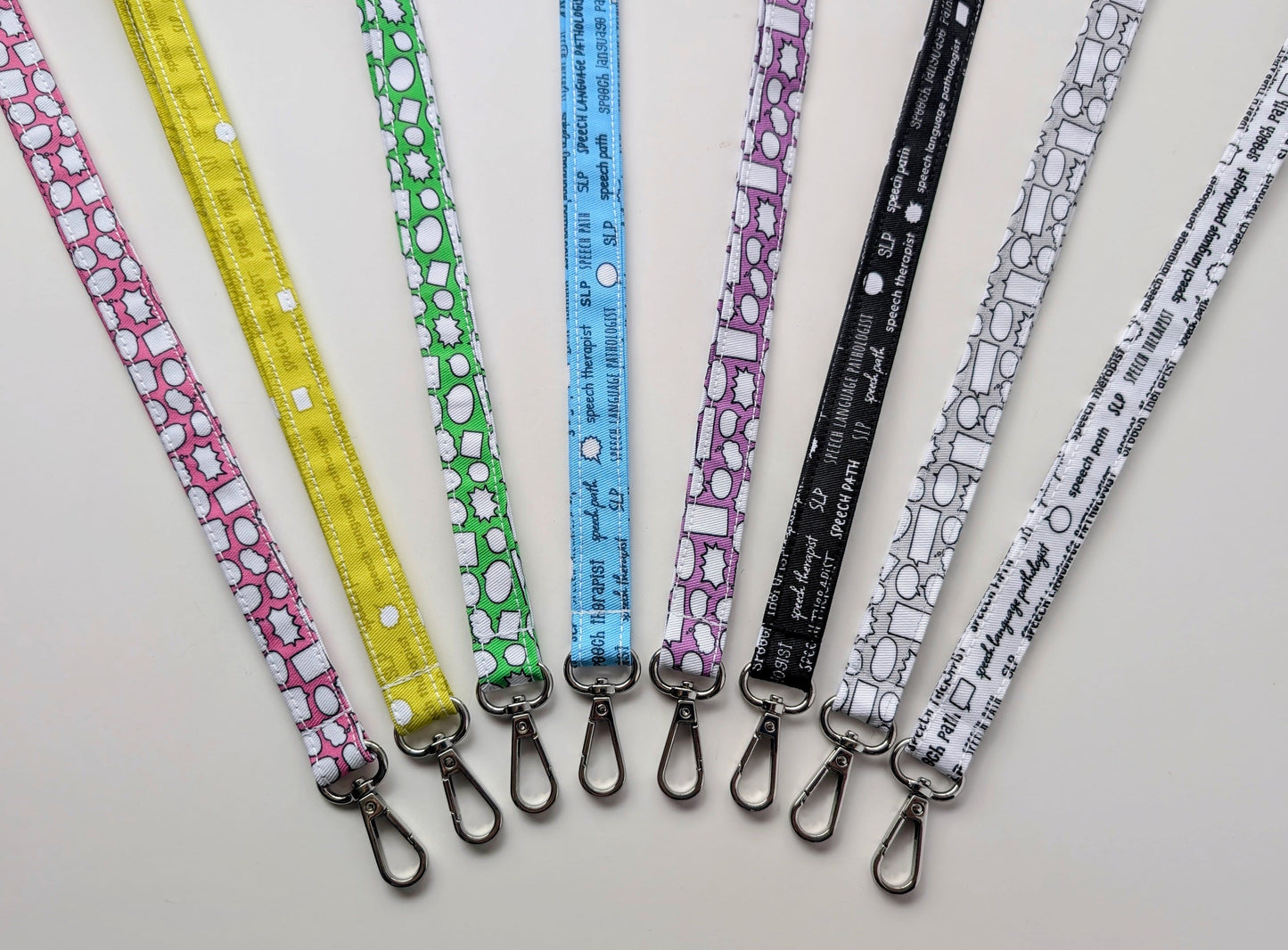 Set of colorful lanyards with various patterns on a light gray background