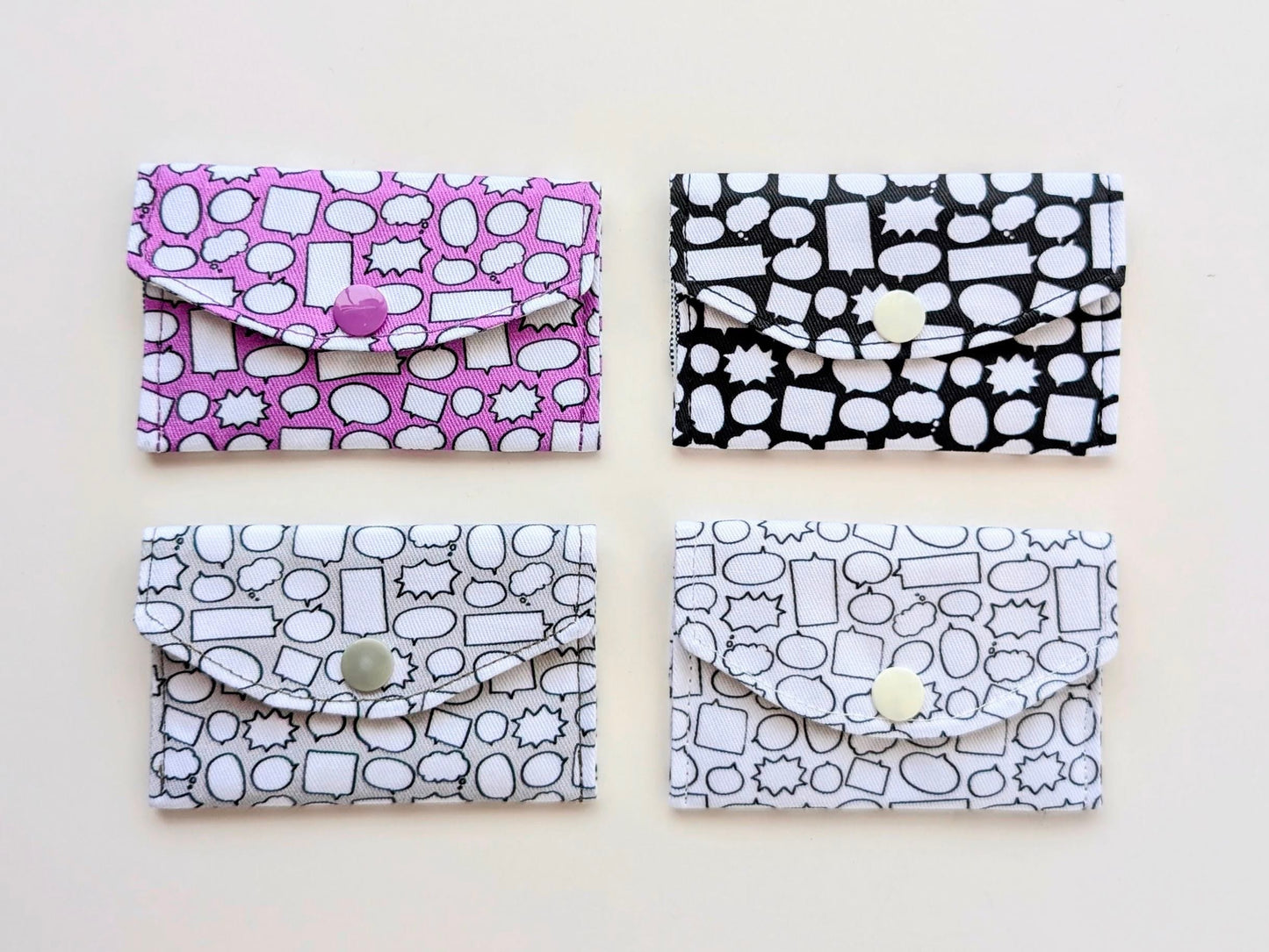 Four patterned wallets in black, white, and purple on a white background