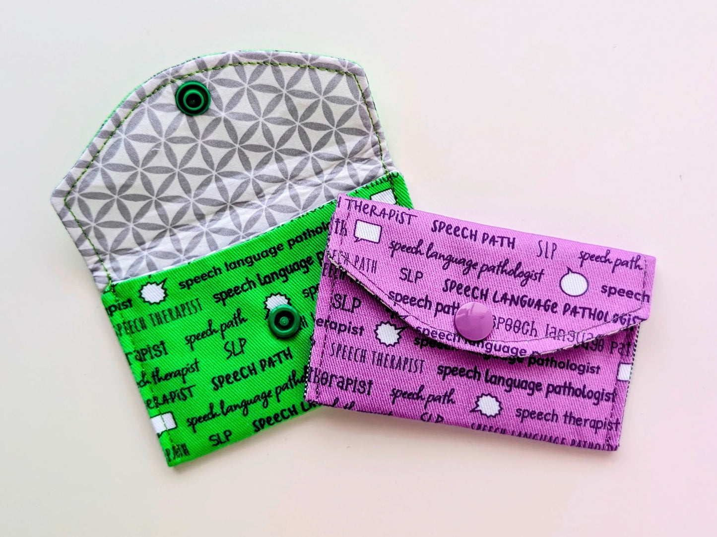 Two fabric pouches with 'speech language pathologist' text on a light background