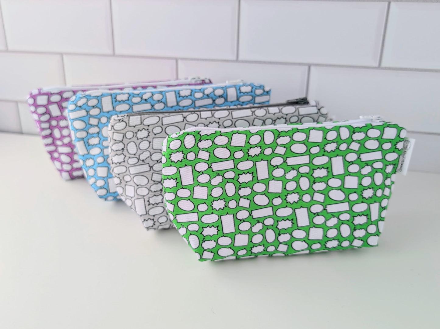 Set of patterned pouches on a white surface with tiled wall background