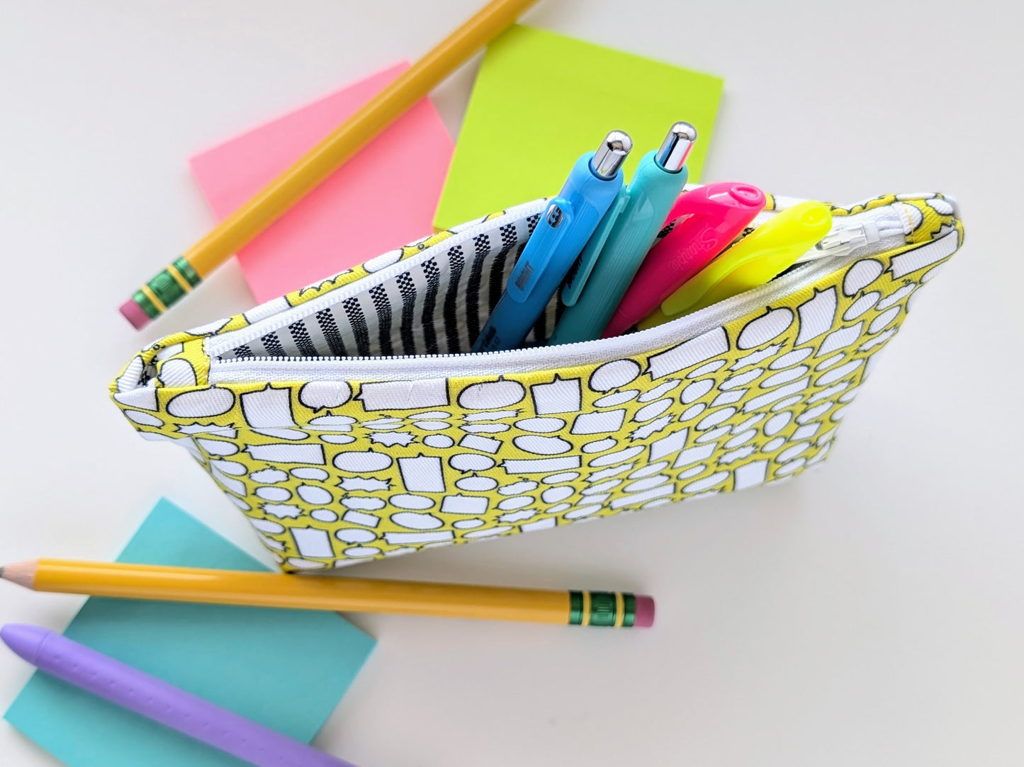 Pencil case with stationery items including pencils and markers on a white background