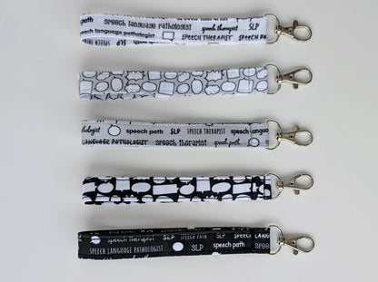 Set of five grayscale lanyards with 'speech language pathologist' text on a white background