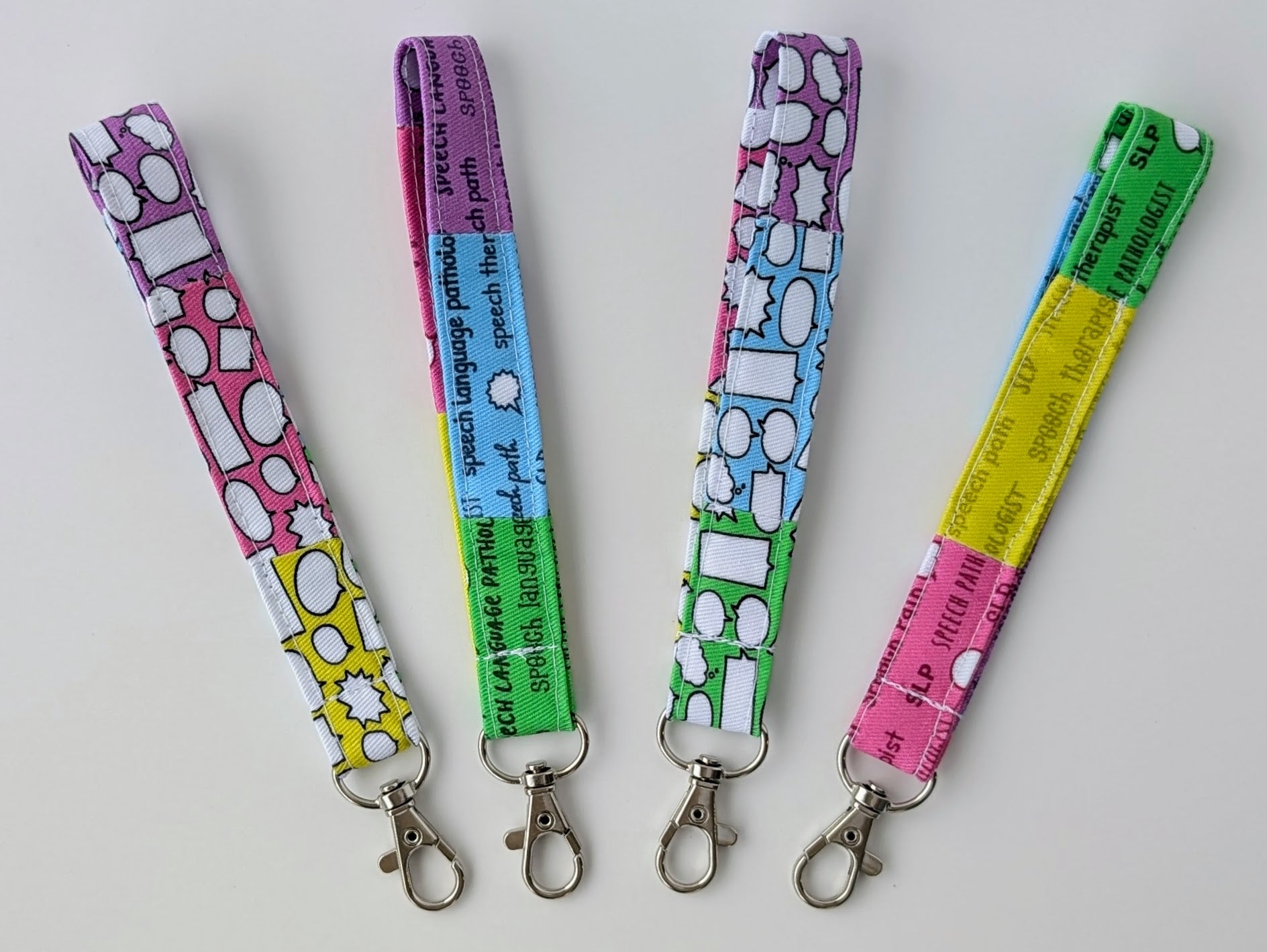 Four colorful lanyards with keychains on a light gray background