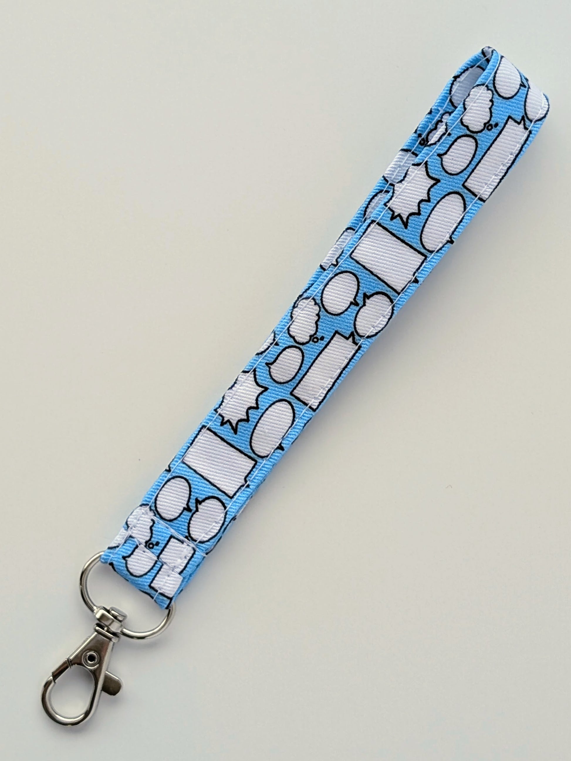 Blue lanyard with white speech bubble pattern on a light gray background