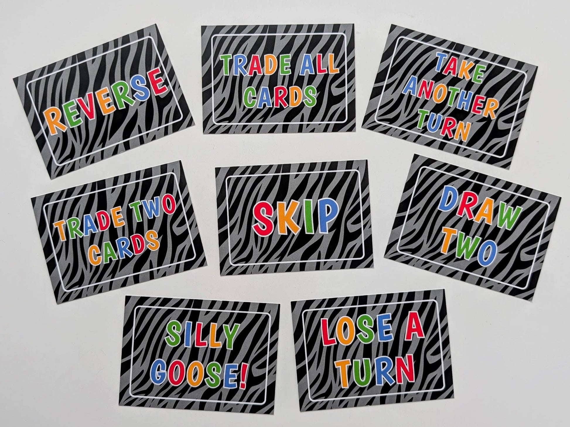 Set of game cards with colorful text on a zebra print background