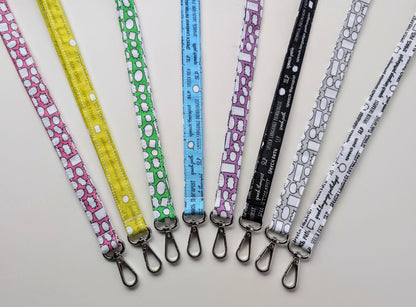Set of colorful lanyards with various patterns on a light gray background