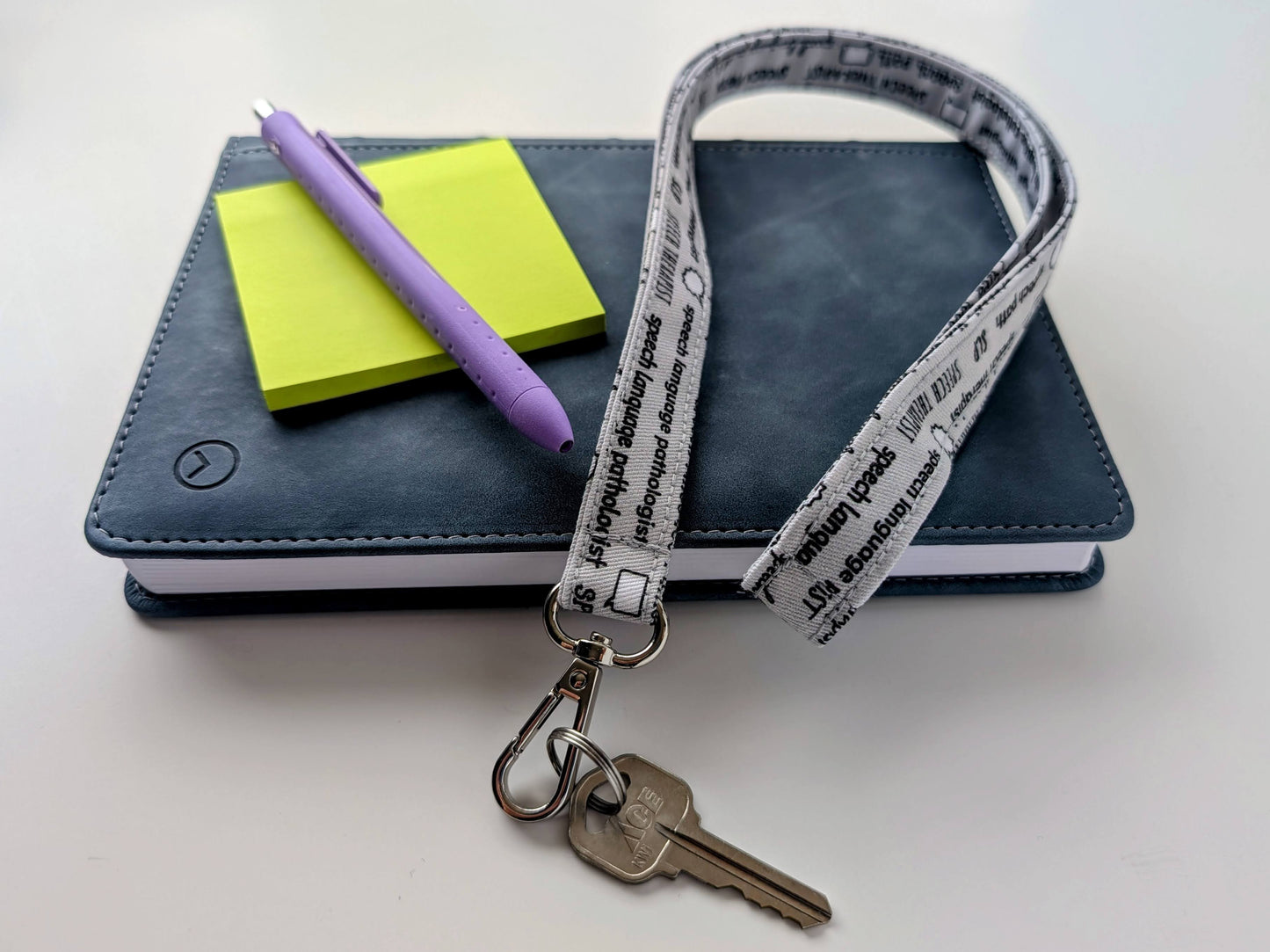 Lanyard with keys, notebook, pen, and paper on a white background