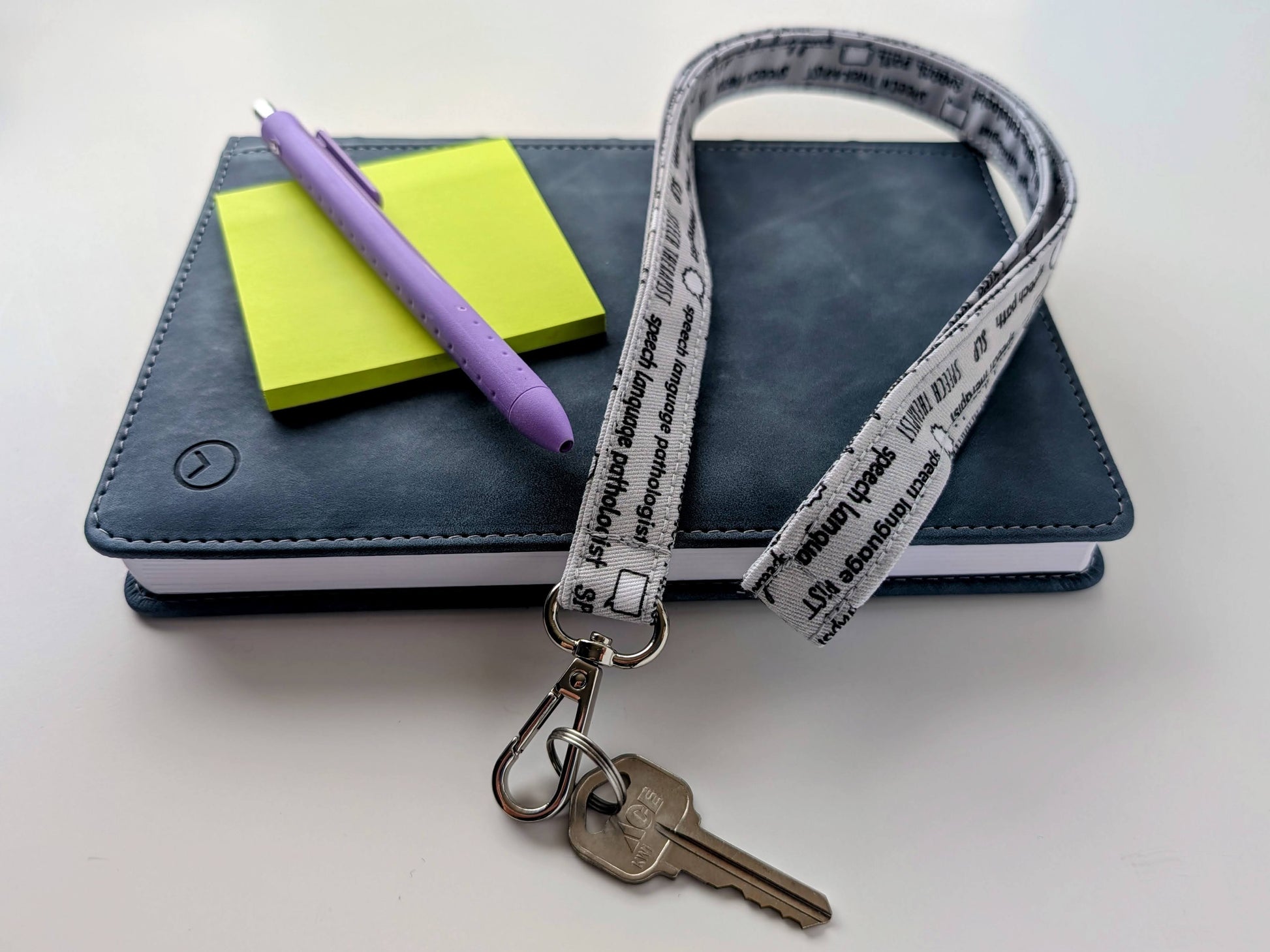 Lanyard with keys, notebook, pen, and paper on a white background
