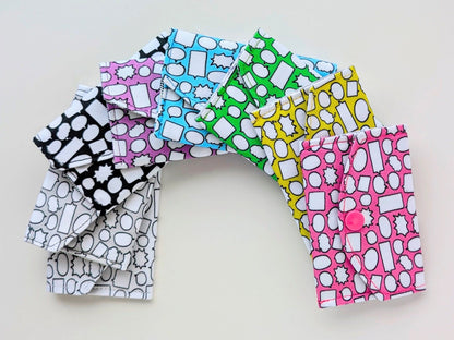 Colorful patterned fabric mini wallets arranged in a semi-circle on a light background
