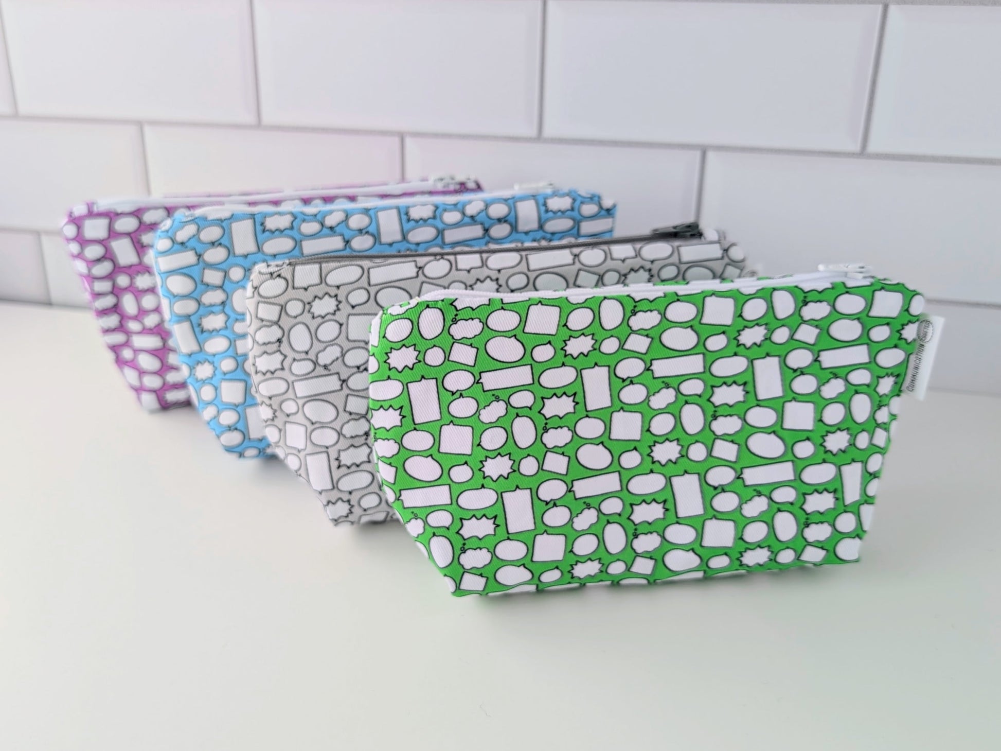 Set of patterned pouches on a white surface with tiled wall background